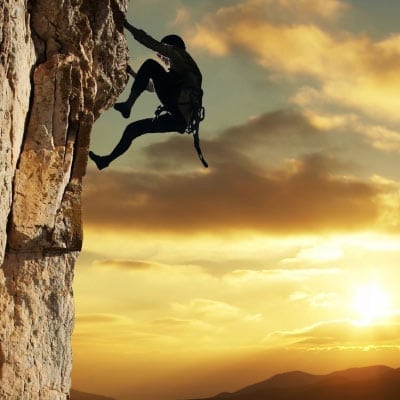 Mountain climber ascending cliff