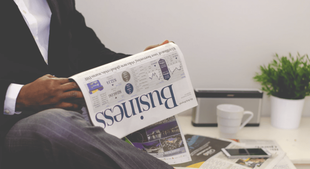 independent consultant in business attire reading business section of a newspaper