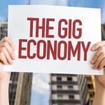 hands holding up a sign saying "the gig economy"