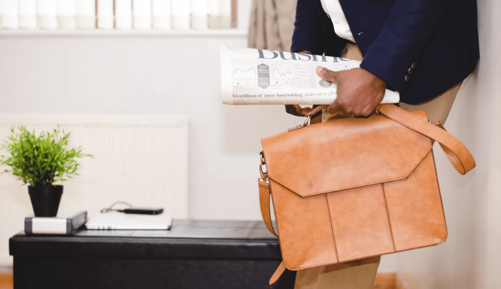 successful consultant leaving home with leather briefcase and paper in hand